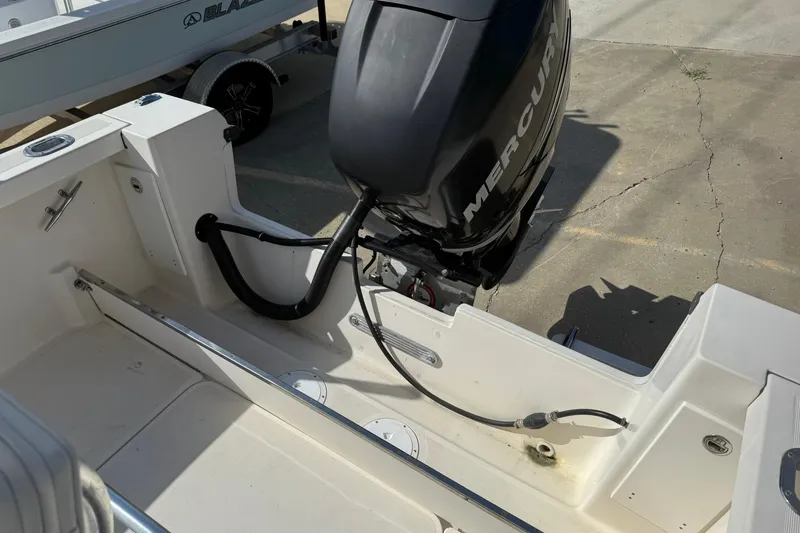 Slide: The Image of 1994 Pursuit 2150 Dual Console boat with Mercury outboard motor, docked on concrete. - 37
