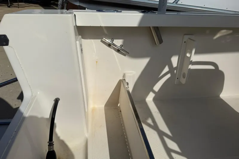 Slide: The Image of 1994 Pursuit 2150 Dual Console boat interior, showing storage compartment and fittings. - 41