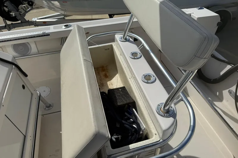 Slide: The Image of 1994 Pursuit 2150 Dual Console boat interior with open storage compartment and seating. - 48