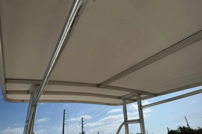 Slide: The Image of 1994 Pursuit 2150 Dual Console boat canopy and frame under clear sky. - 53