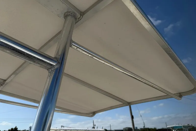 Slide: The Image of 1994 Pursuit 2150 Dual Console boat canopy with metal frame under blue sky. - 54
