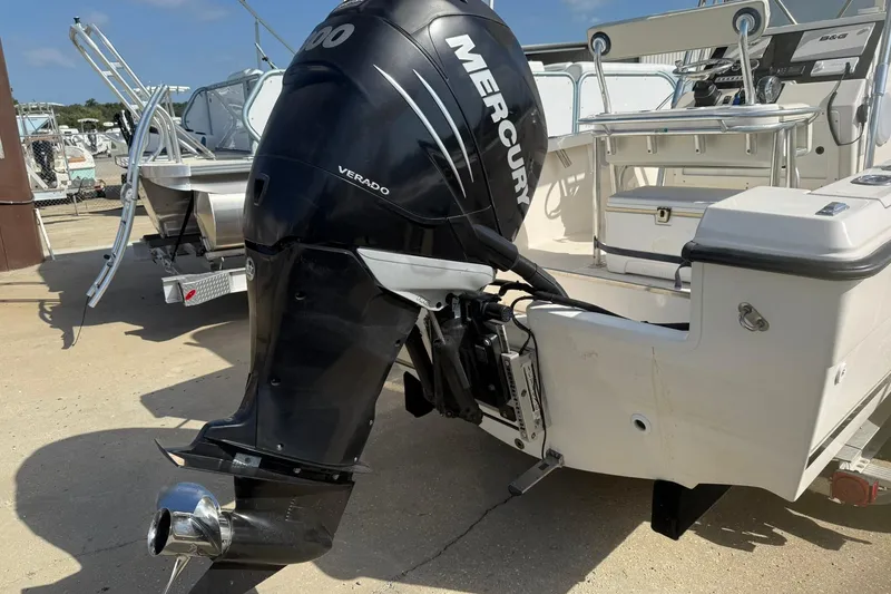 Slide: The Image of 1994 Pursuit 2150 Dual Console boat with Mercury Verado outboard motor, docked on a sunny day. - 56