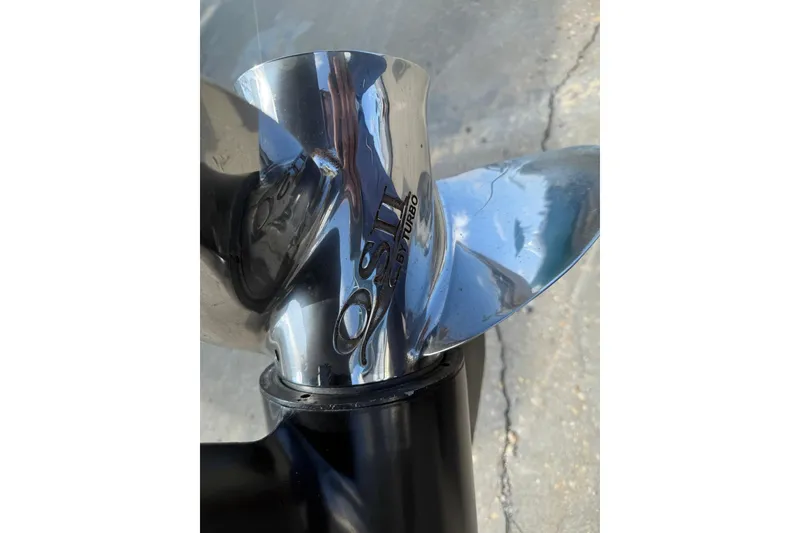 Slide: The Image of Close-up of a stainless steel boat propeller on a 1994 Pursuit 2150 Dual Console. - 57