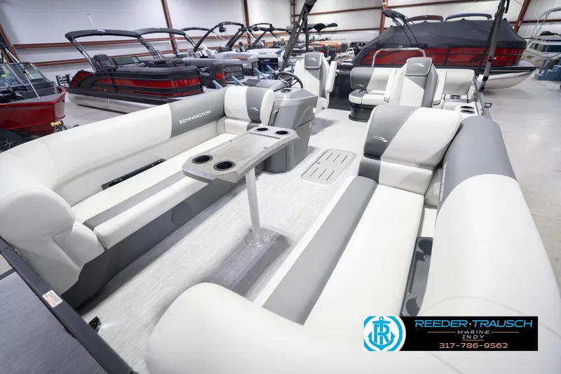 Slide: The Image of 2026 Bennington 22 SSB pontoon boat interior with gray seating and table in showroom. - 12