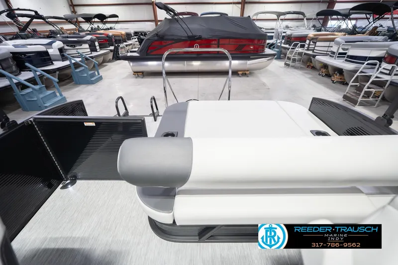 Slide: The Image of 2026 Bennington 22 SSB pontoon boat in showroom, surrounded by other boats. - 18