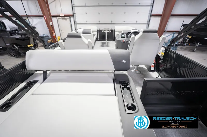 Slide: The Image of 2026 Bennington 22 SSB pontoon boat interior with seating and control panel in showroom. - 19