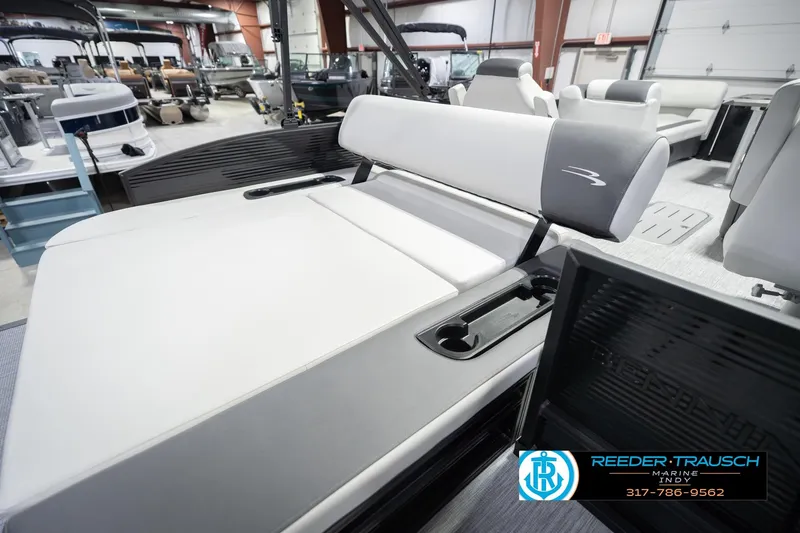 Slide: The Image of 2026 Bennington 22 SSB boat interior with sleek seating and cup holders in showroom. - 28