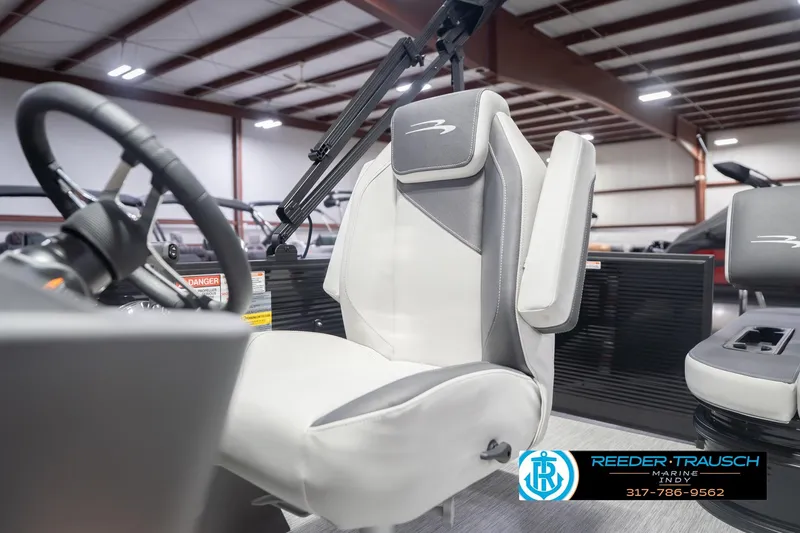 Slide: The Image of 2026 Bennington 22 SSB boat interior with steering wheel and seating in showroom. - 39
