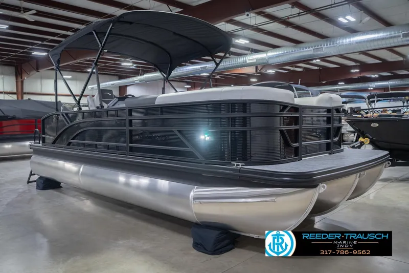 Slide: The Image of 2026 Bennington 22 SSB pontoon boat in showroom, featuring sleek design and canopy. - 6