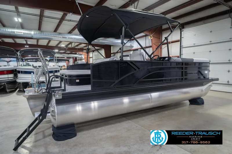 Slide: The Image of 2026 Bennington 22 SSB pontoon boat in showroom, featuring sleek design and canopy. - 8