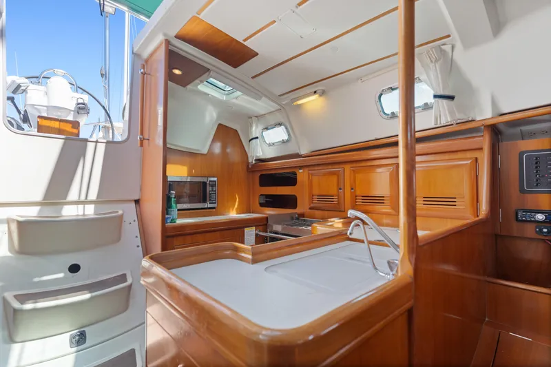 Slide: The Image of Interior of 2001 Beneteau Oceanis 361 sailboat with wooden cabinetry and modern amenities. - 12