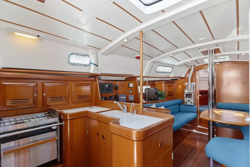 Slide: The Image of Interior of 2001 Beneteau Oceanis 361 yacht with wooden cabinetry and blue seating. - 14