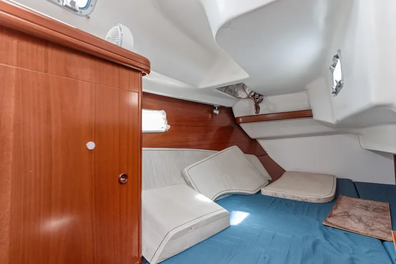 Slide: The Image of Interior cabin of 2001 Beneteau Oceanis 361 sailboat with wooden cabinetry and cushions. - 16
