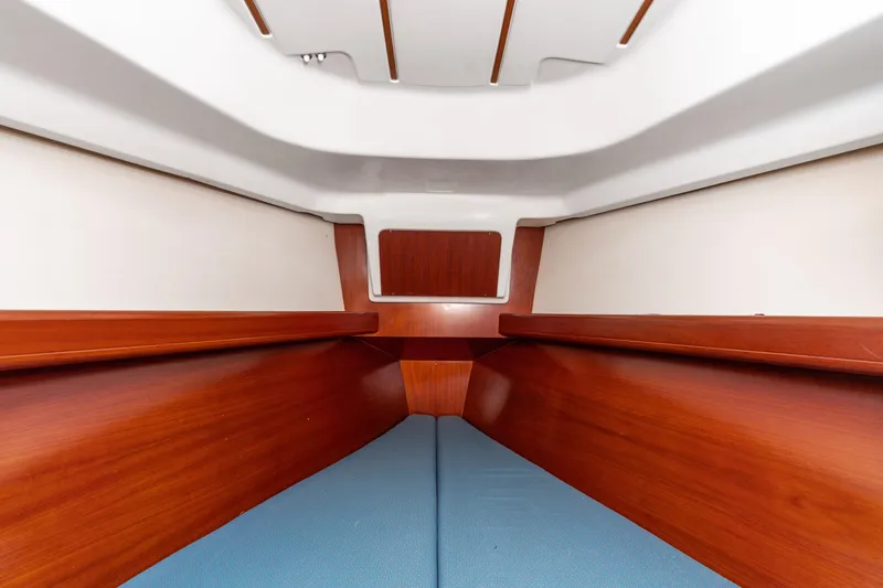 Slide: The Image of Interior cabin of 2001 Beneteau Oceanis 361 sailboat with wooden finish and blue cushions. - 17