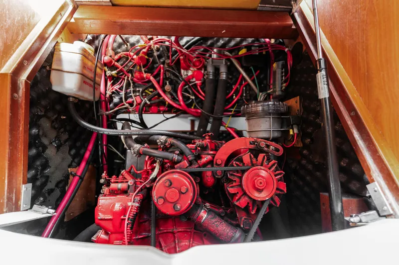 Slide: The Image of Engine compartment of a 2001 Beneteau Oceanis 361 sailboat, showcasing red engine and wiring. - 31