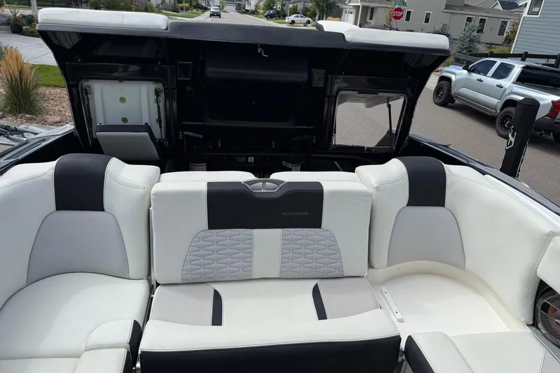 Slide: The Image of 2021 MasterCraft X24 boat interior with white and black seating, open storage compartments. - 3