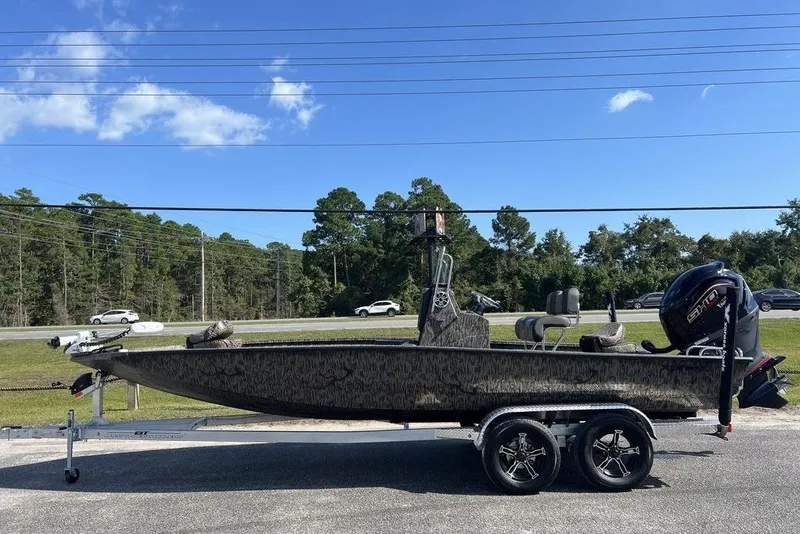 The Image of 2026 Xpress H22B Bay boat on trailer, parked roadside under clear blue sky. - 0