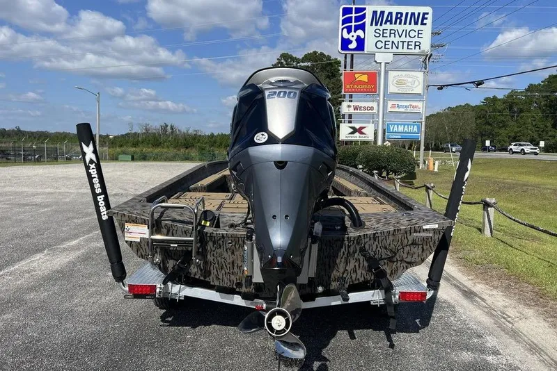 Slide: The Image of 2026 Xpress H22B Bay boat at Marine Service Center, featuring powerful outboard motor. - 10