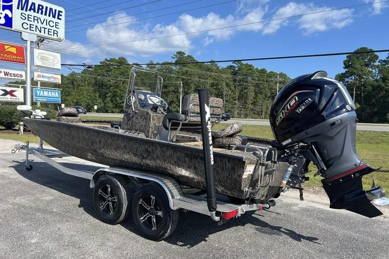 Slide: The Image of 2026 Xpress H22B Bay boat on trailer, parked outdoors under clear sky. - 2