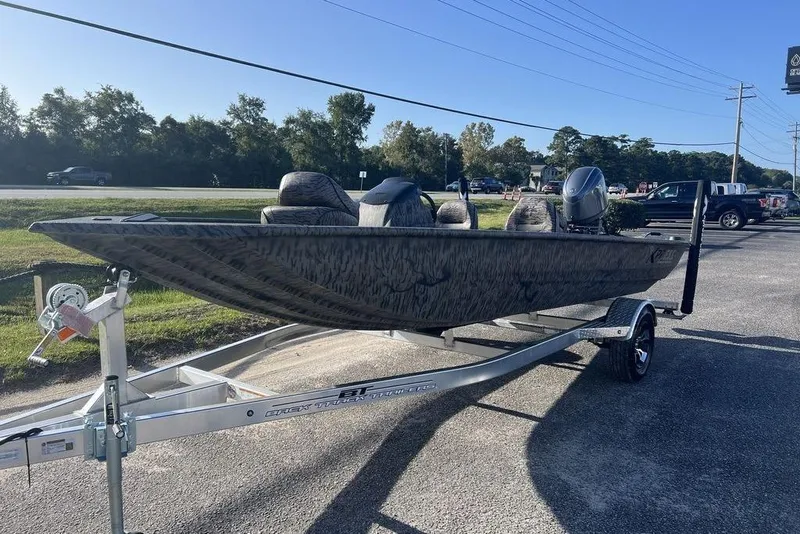 Slide: The Image of 2026 Xpress XP170 boat on trailer outside Marine Service Center under clear blue sky. - 4