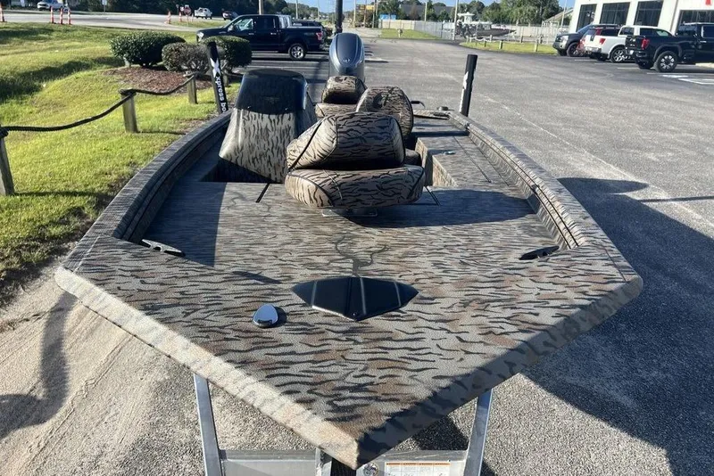 Slide: The Image of 2026 Xpress XP170 boat with camouflage design, parked outdoors on a sunny day. - 7
