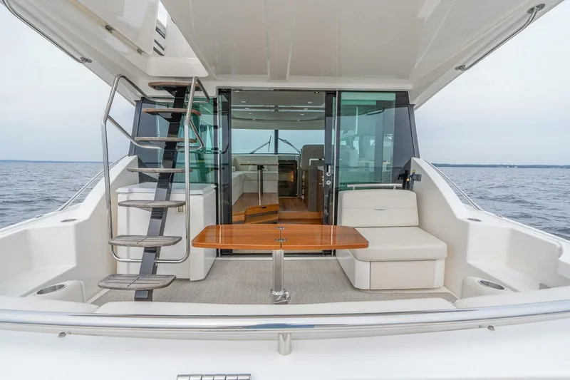 Slide: The Image of 2021 Tiara Yachts F44 Flybridge, elegant deck view with seating and ocean backdrop. - 16