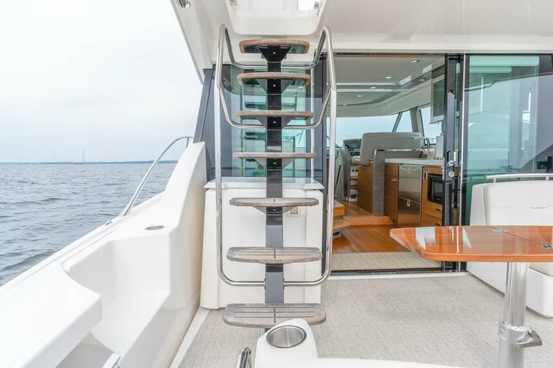 Slide: The Image of 2021 Tiara Yachts F44 Flybridge interior with staircase and ocean view. - 17