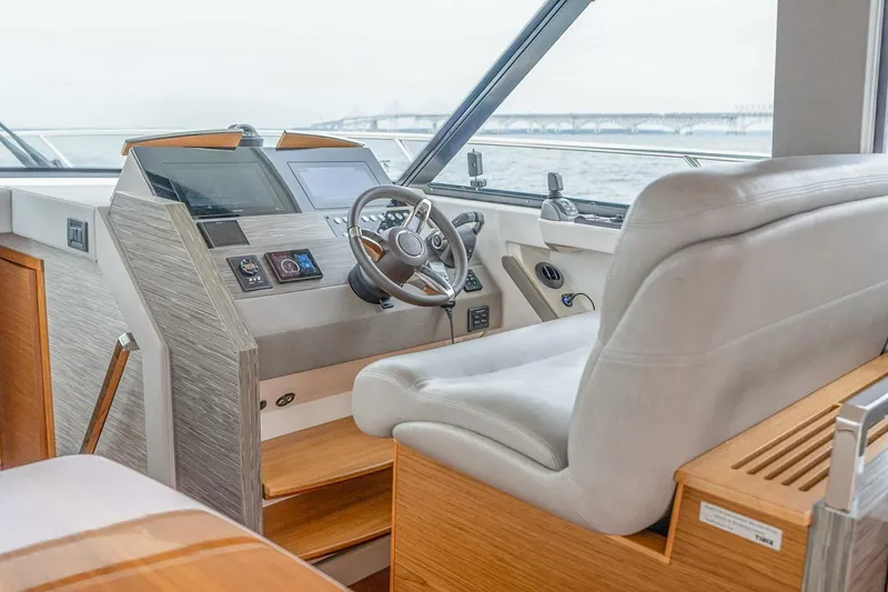 Slide: The Image of 2021 Tiara Yachts F44 Flybridge helm with modern controls and comfortable seating. - 20