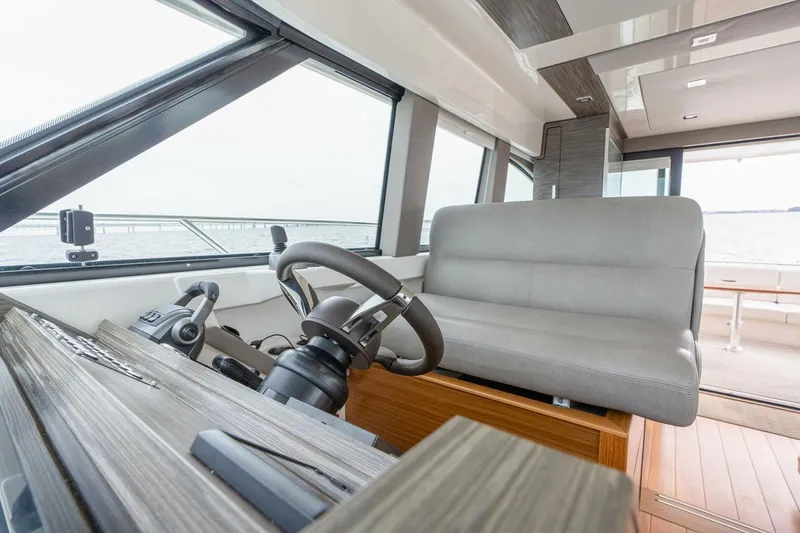 Slide: The Image of 2021 Tiara Yachts F44 Flybridge helm with modern controls and seating. - 24