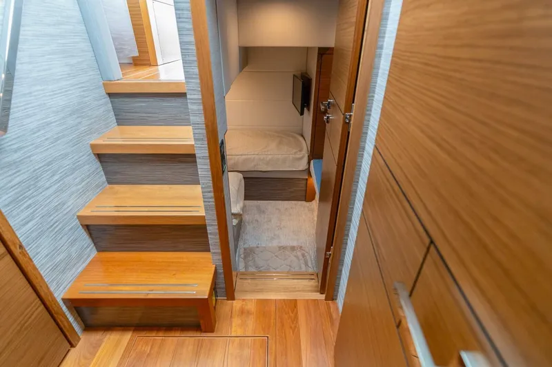 Slide: The Image of Interior of 2021 Tiara Yachts F44 Flybridge, featuring wooden stairs and cozy cabin. - 36