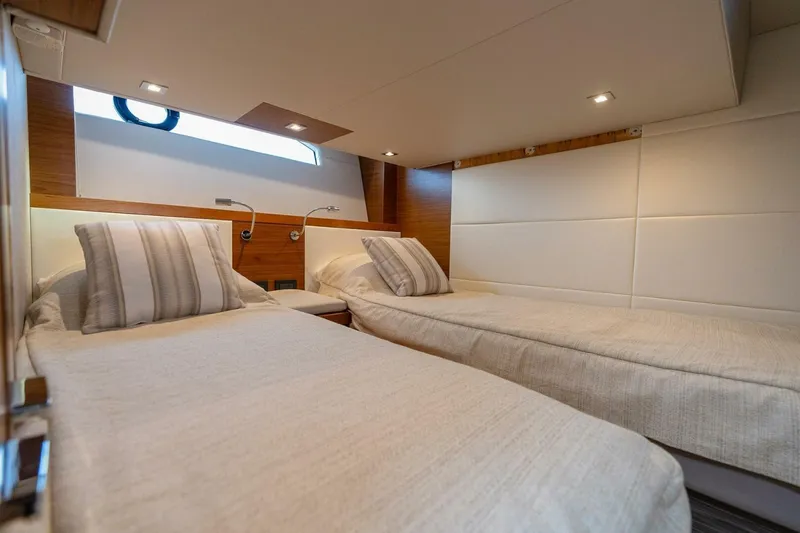 Slide: The Image of 2021 Tiara Yachts F44 Flybridge cabin with twin beds and modern decor. - 37