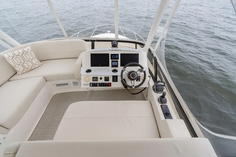 Slide: The Image of 2021 Tiara Yachts F44 Flybridge helm with modern controls and plush seating. - 52