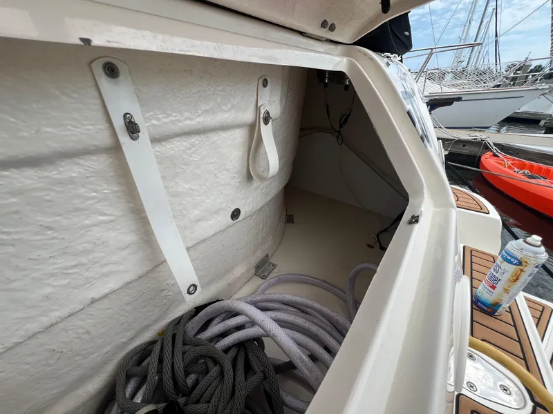 Slide: The Image of Storage compartment of a 2003 Sea Ray 320 Sundancer with ropes and cleaning supplies. - 40