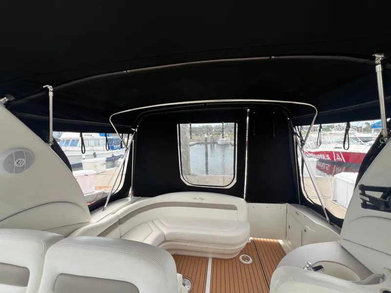 Slide: The Image of 2003 Sea Ray 320 Sundancer interior with white seating and black canopy. - 34