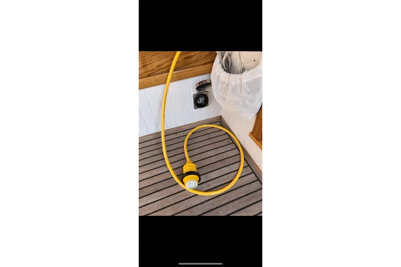 Slide: The Image of Interior of 2017 Classic Dark Harbor 17 1/2 sailboat with wooden finish and stored equipment. - 24