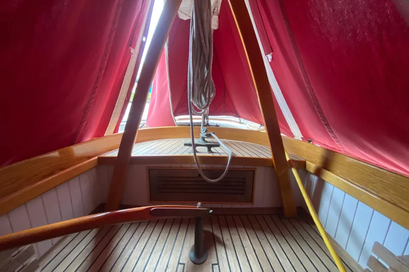 Slide: The Image of Interior of 2017 Classic Dark Harbor 17 1/2 sailboat with red canopy and wooden deck. - 31