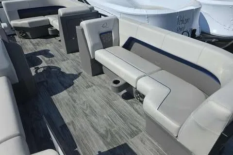 Slide: The Image of 2026 Qwest XRE E-Class boat interior with gray seating and wood-style flooring. - 2