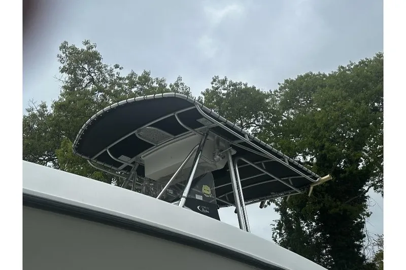 Slide: The Image of 2000 Hydra-Sports 2796 CC Vector boat with canopy, set against a cloudy sky and trees. - 10