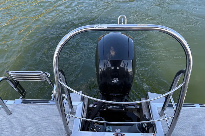 Slide: The Image of 2023 Harris HCX 230 Stern Radius boat engine and railing on water. - 12