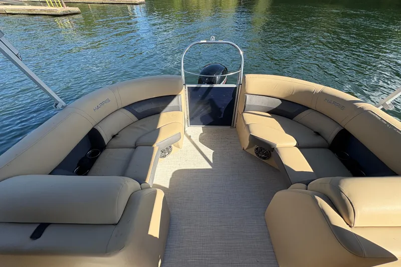 Slide: The Image of 2023 Harris HCX 230 Stern Radius pontoon boat with beige seating on a sunny day. - 13