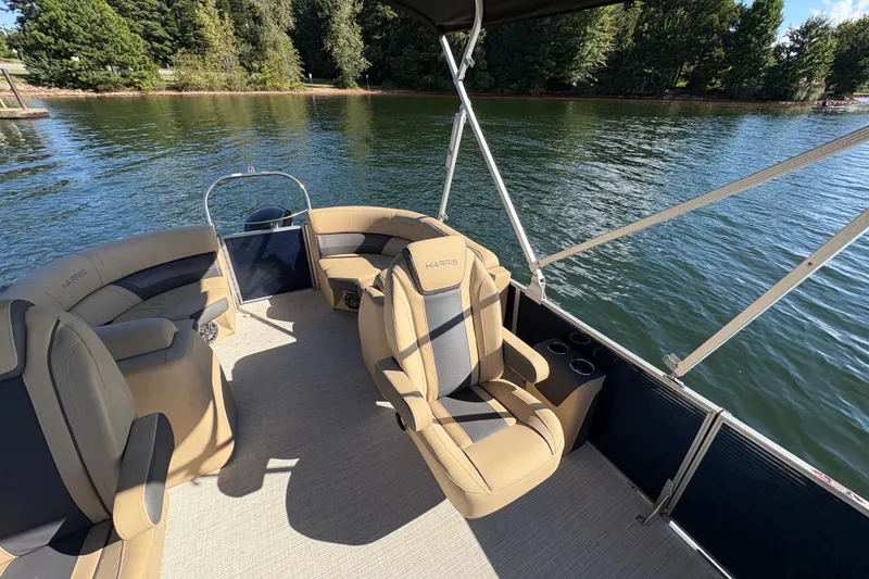 Slide: The Image of 2023 Harris HCX 230 Stern Radius pontoon boat interior on a scenic lake. - 15