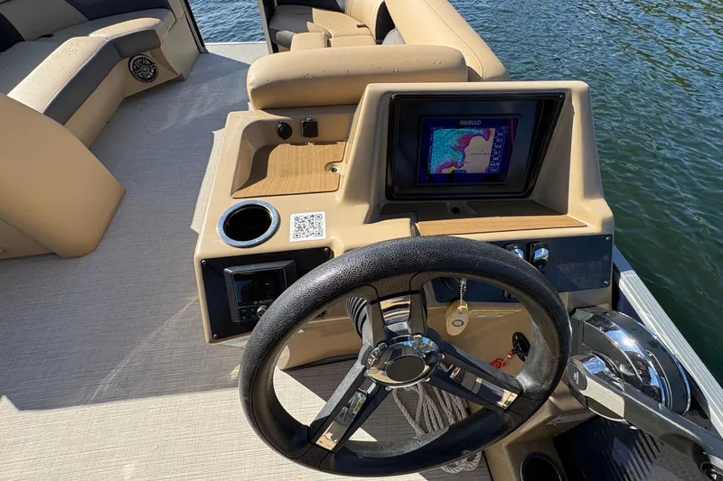 Slide: The Image of 2023 Harris HCX 230 Stern Radius boat dashboard with steering wheel and navigation display. - 16
