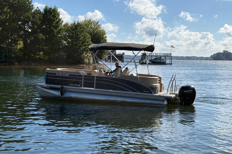 Slide: The Image of 2023 Harris HCX 230 Stern Radius pontoon boat on a sunny lake. - 6