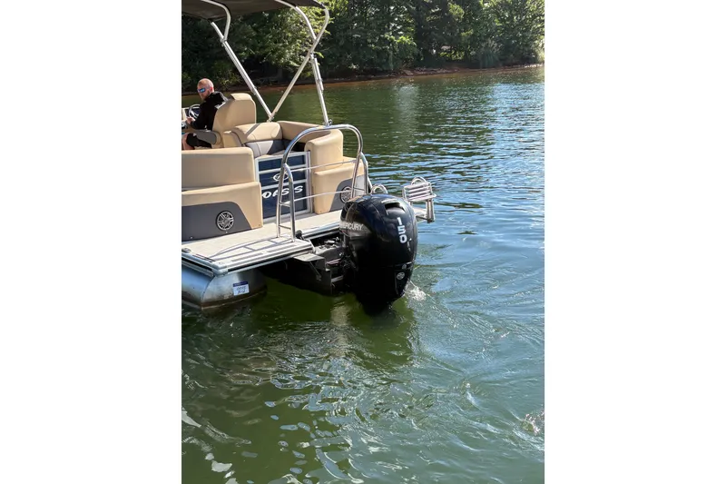 Slide: The Image of 2023 Harris HCX 230 Stern Radius pontoon boat on a lake with Mercury outboard motor. - 9