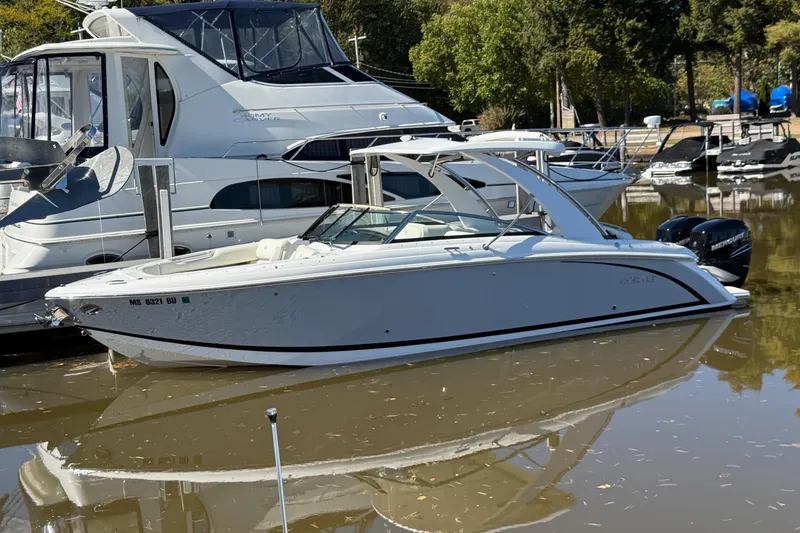 Slide: The Image of 2021 Cobalt 30SC boat docked in marina, surrounded by other vessels. - 2