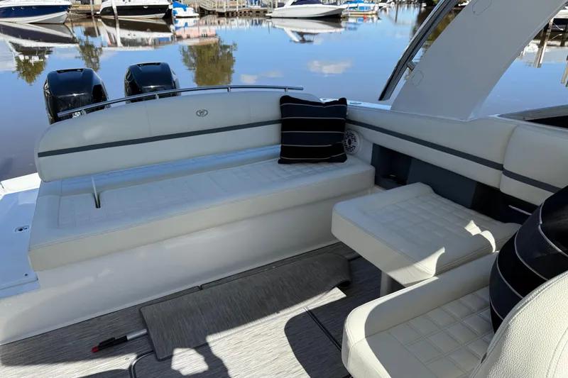 Slide: The Image of 2021 Cobalt 30SC boat interior with cushioned seating and striped pillows. - 8