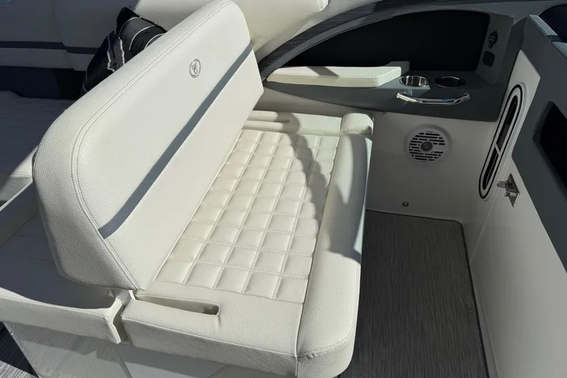 Slide: The Image of 2021 Cobalt 30SC boat interior with white cushioned seating and cup holders. - 9