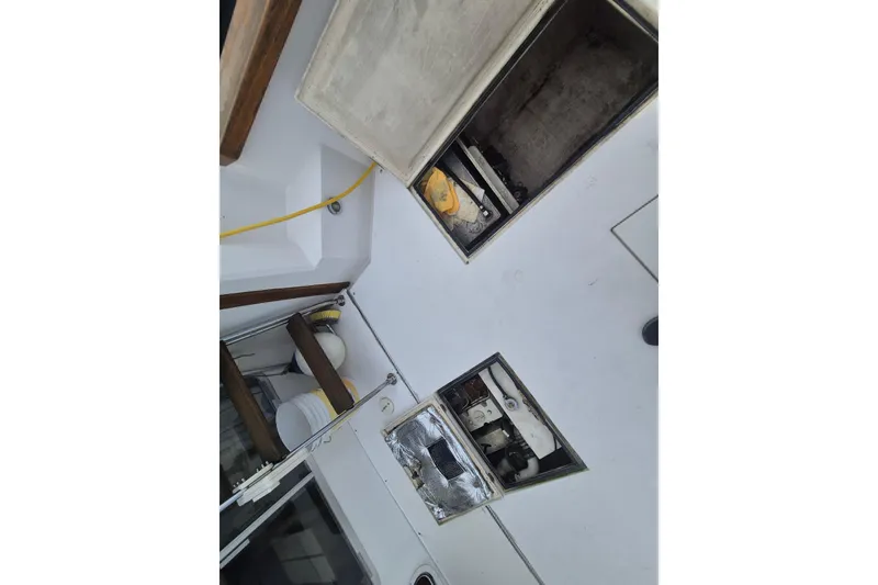 Slide: The Image of 1999 Nauset 33 Bridge Deck boat interior with open storage compartments and visible equipment. - 24