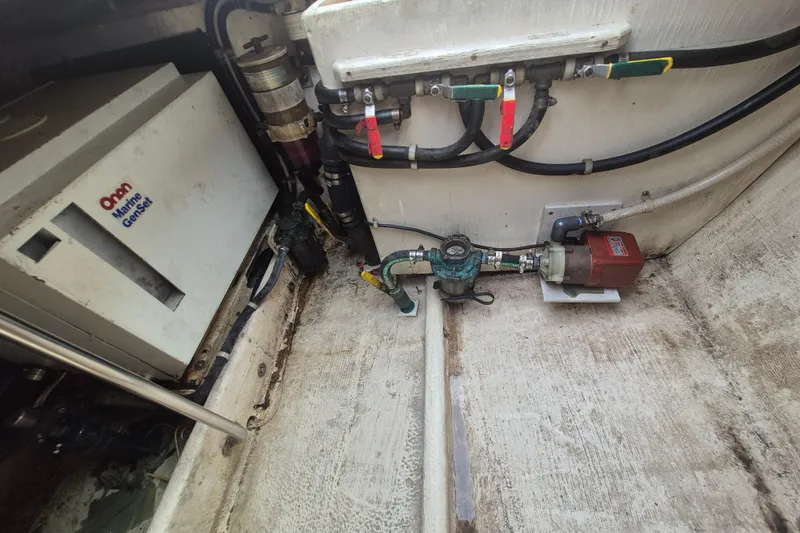 Slide: The Image of Engine room of 1999 Nauset 33 Bridge Deck with Onan Marine Genset and plumbing components. - 25