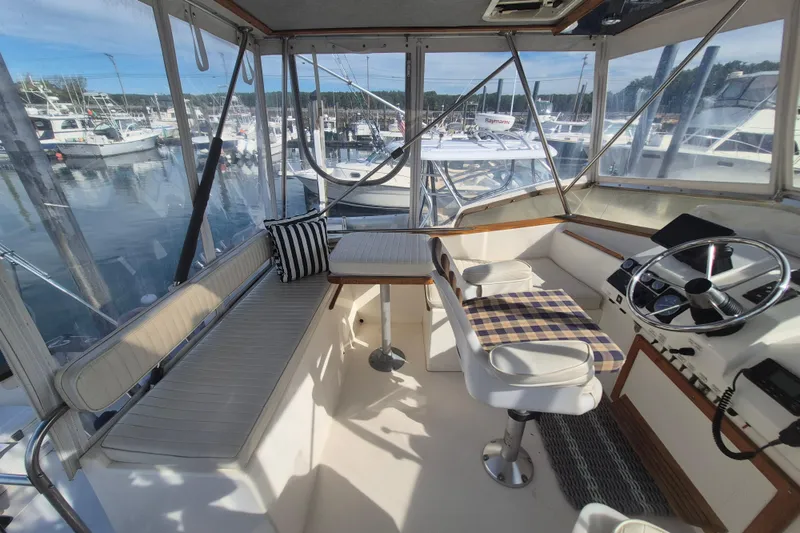 Slide: The Image of Interior of 1999 Nauset 33 Bridge Deck boat with seating and steering wheel. - 35